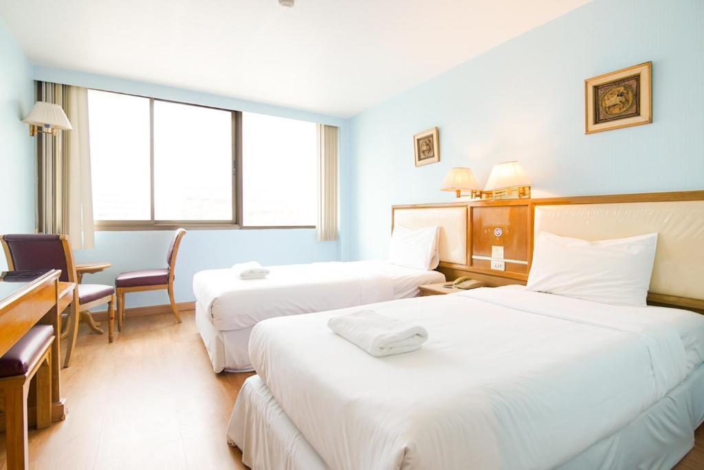 a hotel room with two beds and a desk at Wish Inn Chidlom - CentlralWorld By GO INN in Makkasan