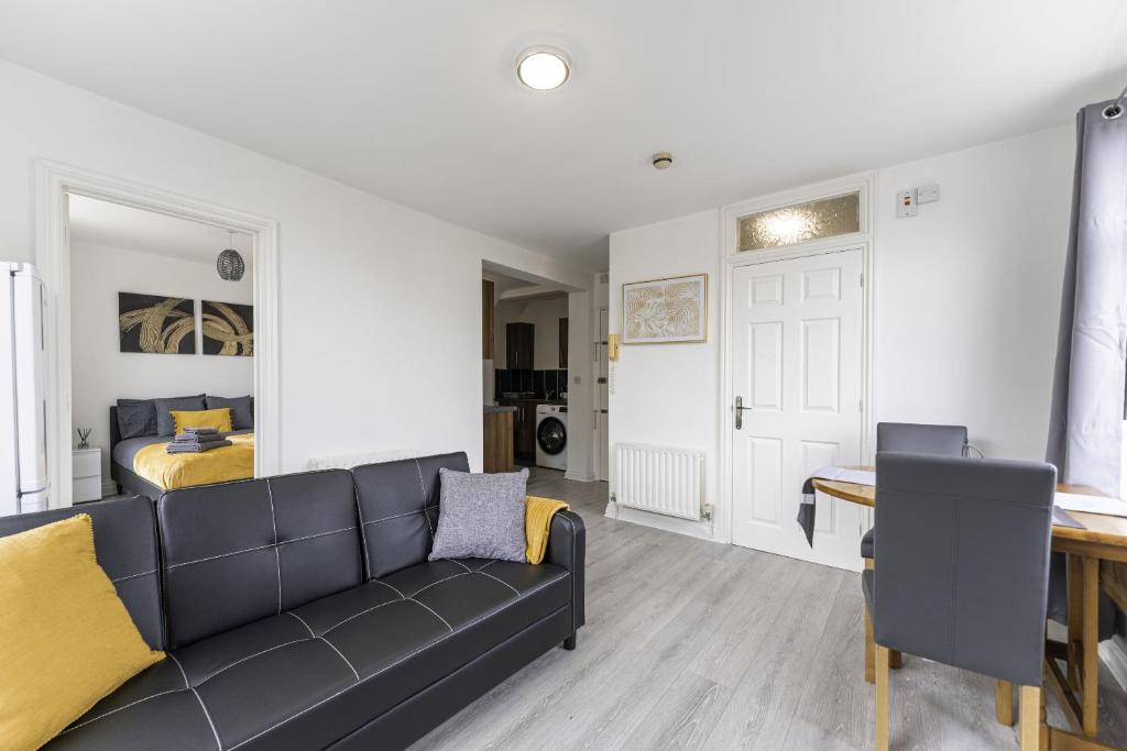 uma sala de estar com um sofá e um quarto em Comfy Stay 1 Bedroom Apartment em Rugby