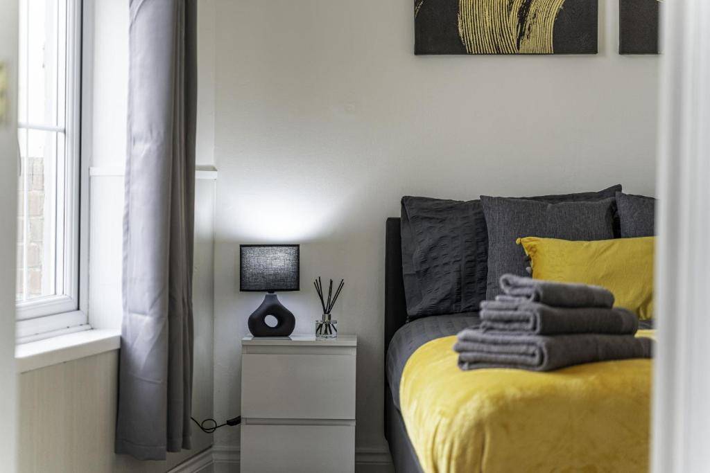 a bedroom with a yellow bed and a window at Comfy Stay 1 Bedroom Apartment in Rugby