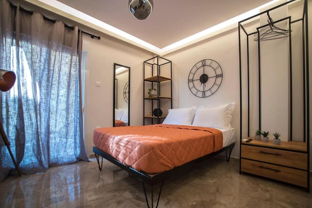 een slaapkamer met een bed en een klok aan de muur bij Wanderer, Nilie Hospitality MGMT in Thessaloniki