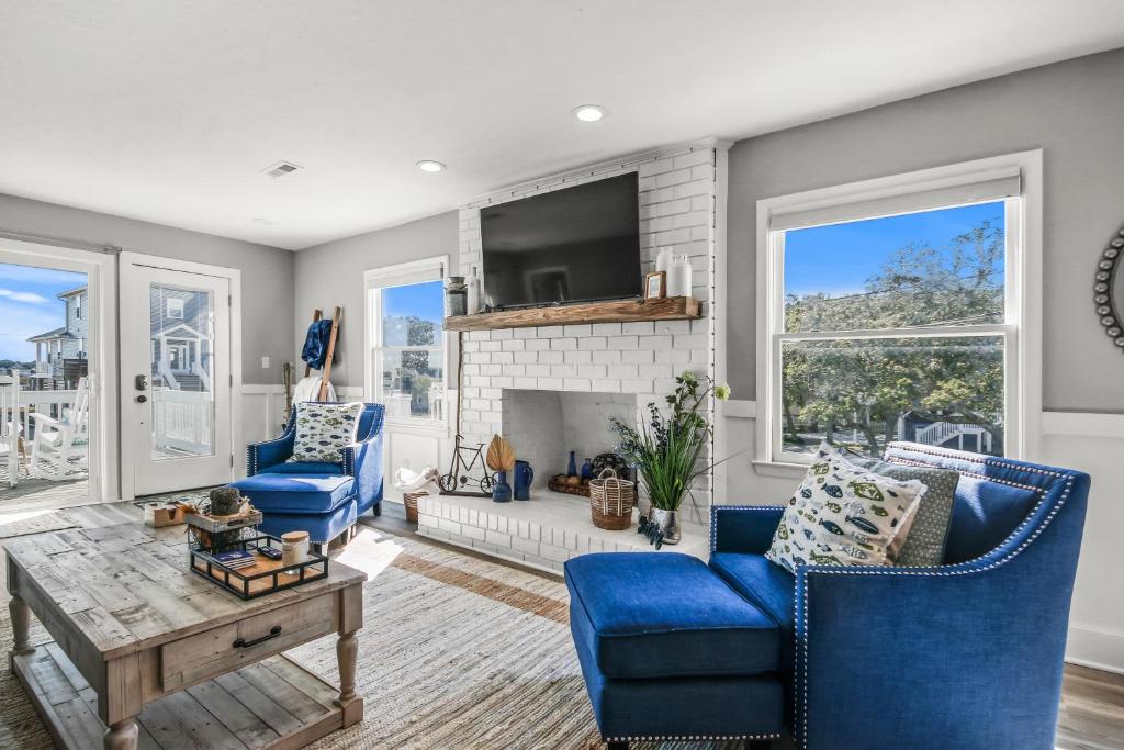 a living room with blue chairs and a fireplace at Coastal Gem of Murrells Inlet in Myrtle Beach