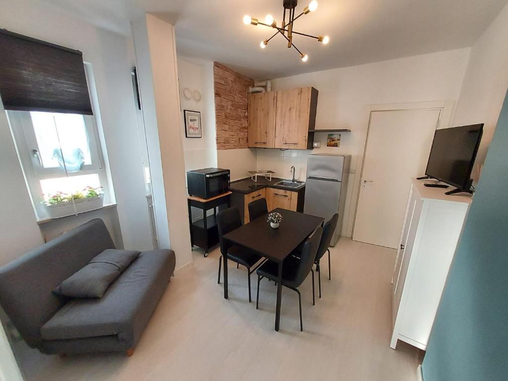 uma sala de estar com um sofá, uma mesa e uma cozinha em ApartmentsGarda - Velia 23 em Lazise