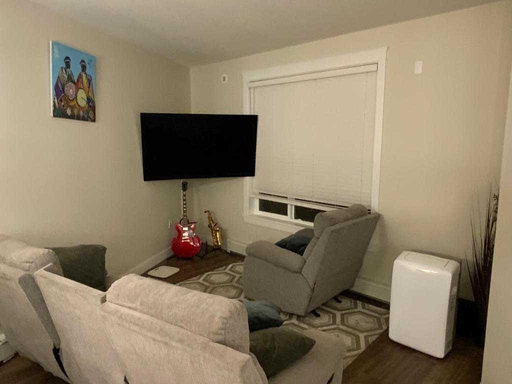 a living room with two chairs and a flat screen tv at Cozy Living in Surrey