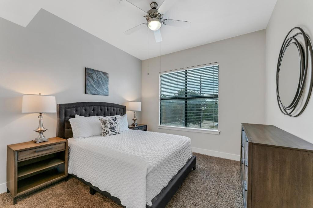 een slaapkamer met een bed en een spiegel bij Beautiful 1br Apartment, Pool, Gym, Parking Cs in Dallas