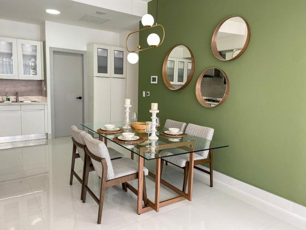 uma sala de jantar com mesa, cadeiras e espelhos em Moderno y acogedor apartamento en Santo Domingo. em Santo Domingo