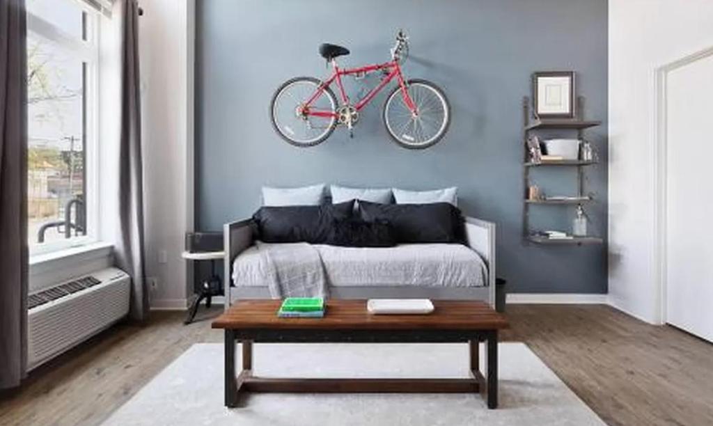 a bedroom with a bed with a bike on the wall at Restful Studio Apartment in NYC! in New York