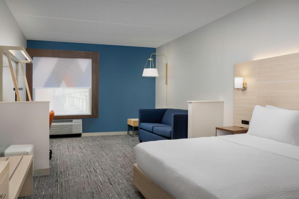a hotel room with a bed and a blue wall at Holiday Inn Express & Suites Pittsburgh North Shore by IHG in Pittsburgh