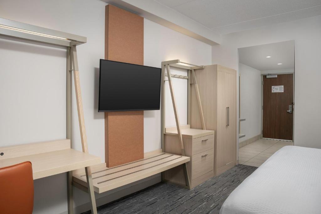 a room with a bed and a desk with a television at Holiday Inn Express & Suites Pittsburgh North Shore by IHG in Pittsburgh