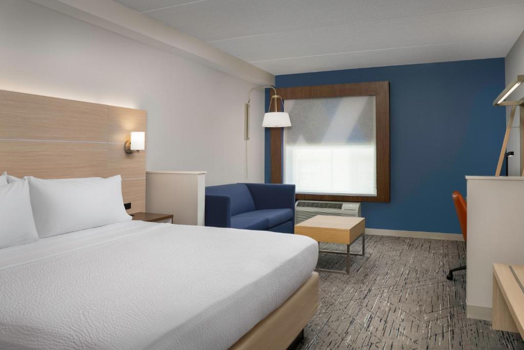 a hotel room with a bed and a blue wall at Holiday Inn Express & Suites Pittsburgh North Shore by IHG in Pittsburgh