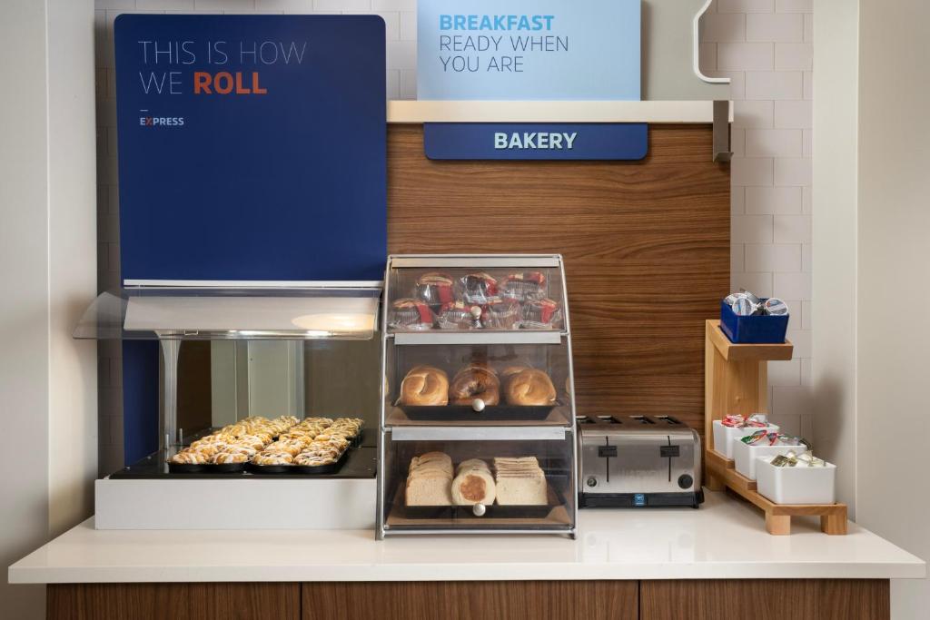 a bakery counter with pastries and a display at Holiday Inn Express & Suites Pittsburgh North Shore by IHG in Pittsburgh