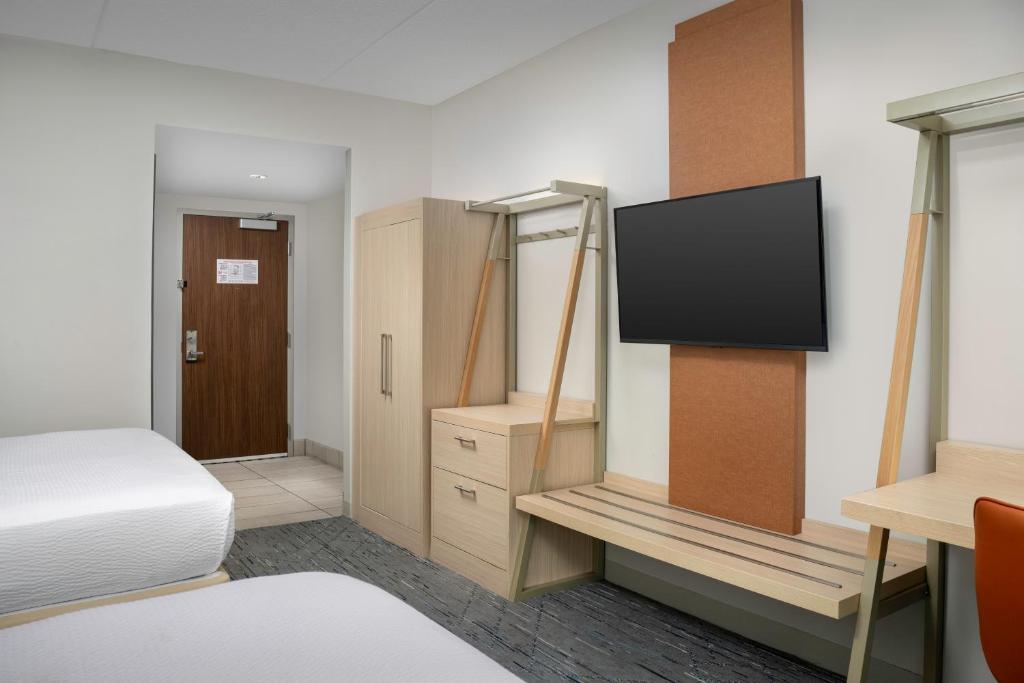a bedroom with a bed and a tv on a wall at Holiday Inn Express & Suites Pittsburgh North Shore by IHG in Pittsburgh