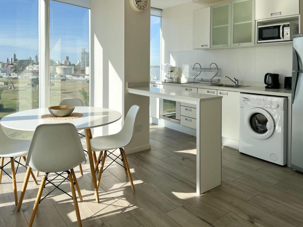 a kitchen with a table and chairs and a kitchen with a washing machine at Departamento de un dormitorio - AMARRAS CENTER in Santa Fe