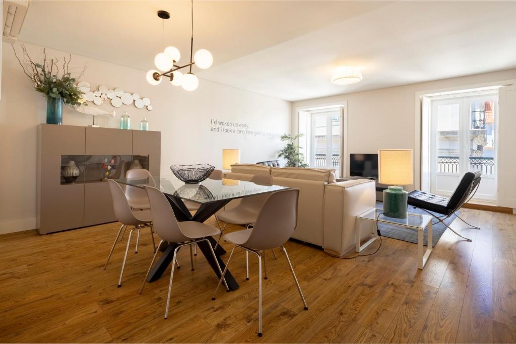 - un salon avec une table, des chaises et un canapé dans l'établissement Chiado Square Apartments | Lisbon Best Apartments, à Lisbonne