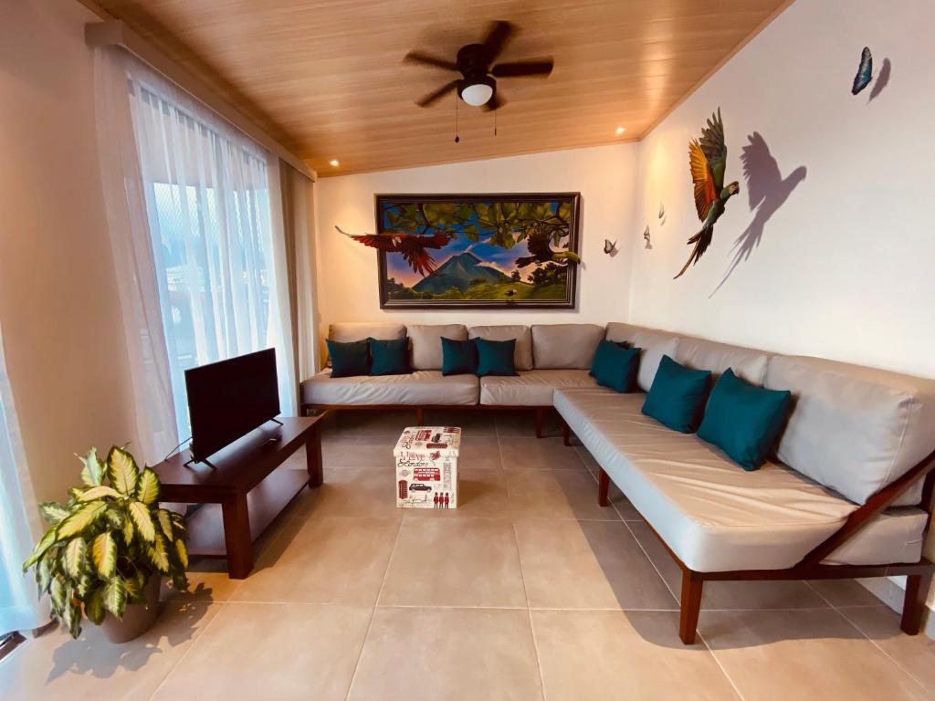 a living room with a couch and a ceiling fan at Casa Macaw in Fortuna