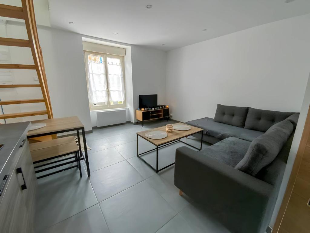 un salon avec un canapé et une table dans l'établissement Lutece - Parking - Jardin - 4pers - Rêve au Mans, à Parigné-lʼÉvêque