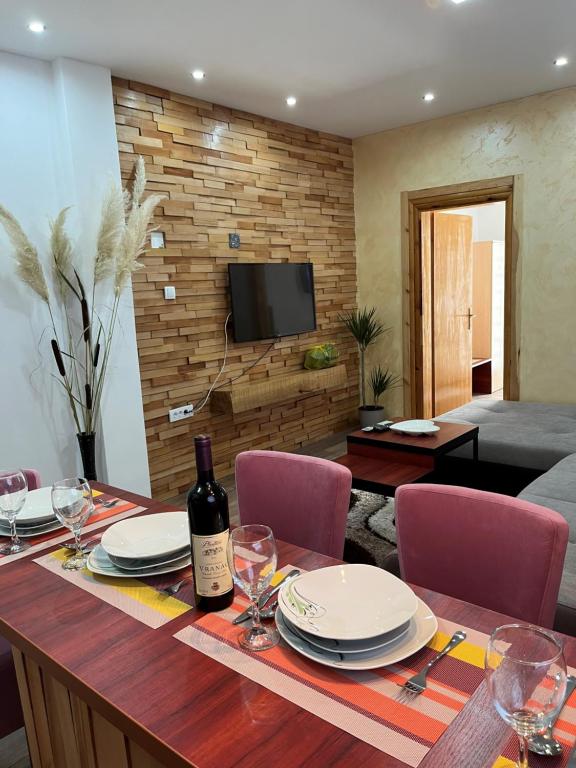 a dining room with a table with a bottle of wine at Apartman's Ana Pale-OC Jahorina No.3 in Pale