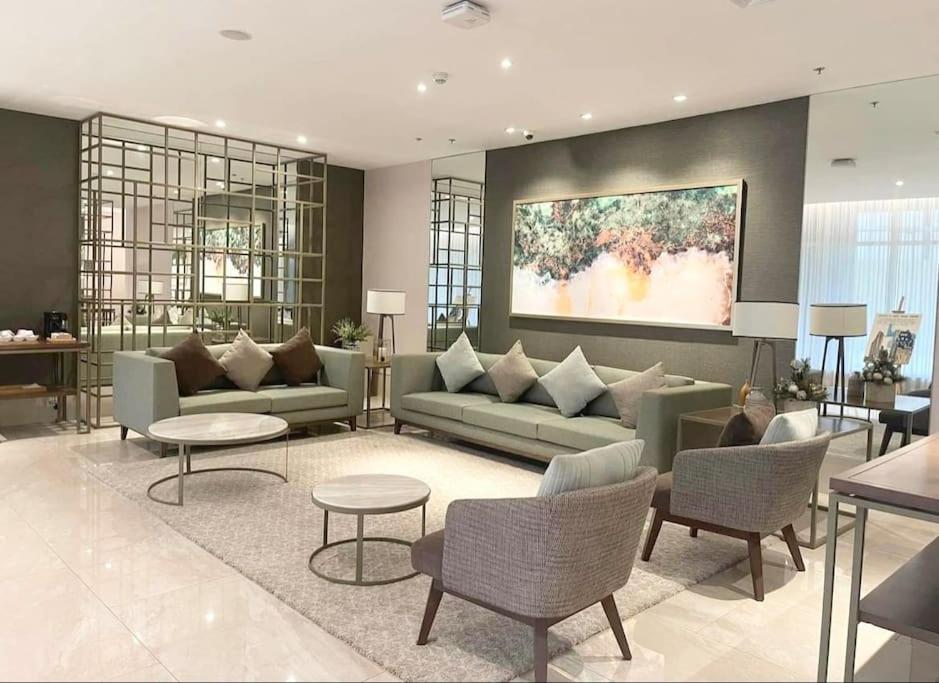 a living room with couches and tables and a painting at Dreamy Aesthetic Suite in City Center in Cebu City