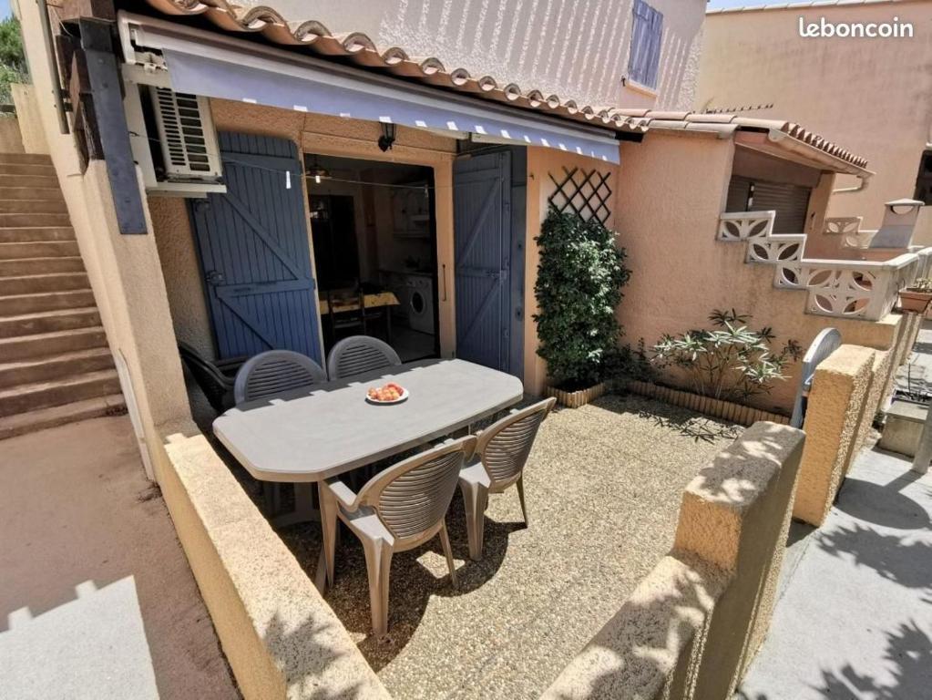 a table and chairs on a patio outside a house at Sur la Presqu&#39;île des Dosses in Le Barcarès
