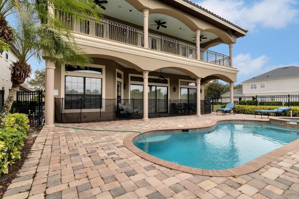 a house with a swimming pool in front of a house at Luxury 5 bed 5.5 bath Villa close to everything in Kissimmee