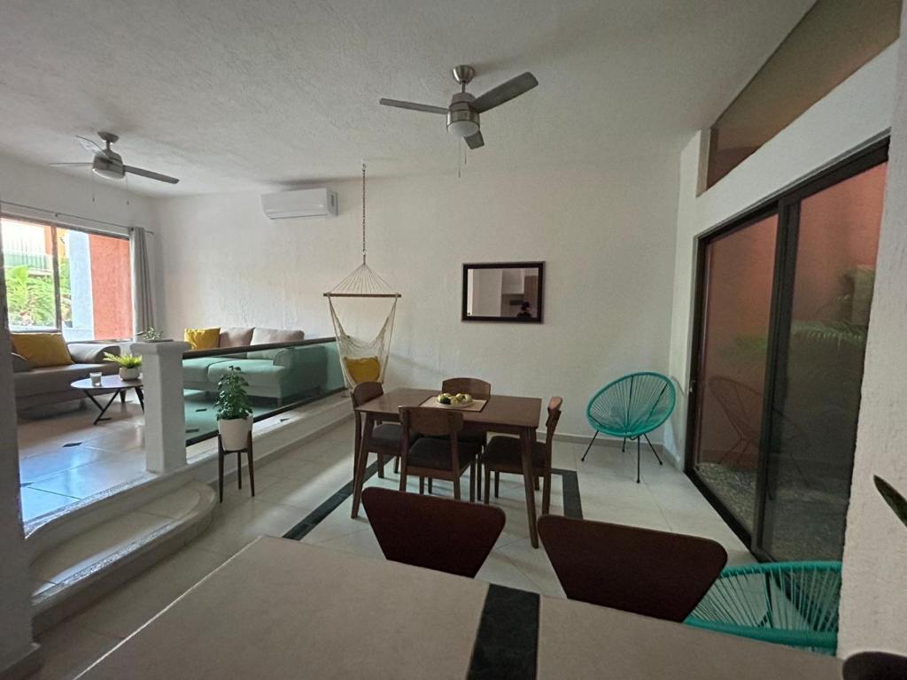 a dining room and living room with a table and chairs at Casa Spa Palmeras - Habitación Privada in Cancún