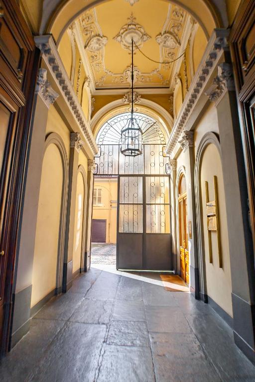 an empty hallway in a building with a chandelier at Vittorio 73 Luxury Apartment in Turin