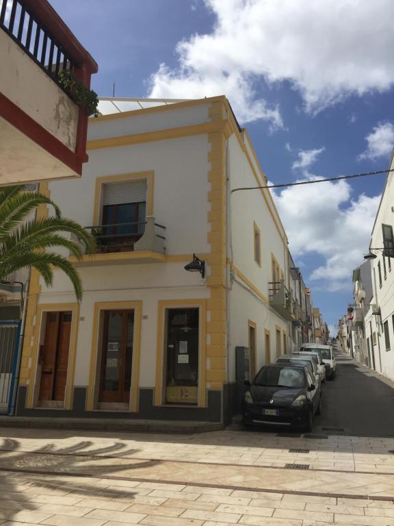 a street with cars parked in front of a building at Monolocale centro storico in Calasetta