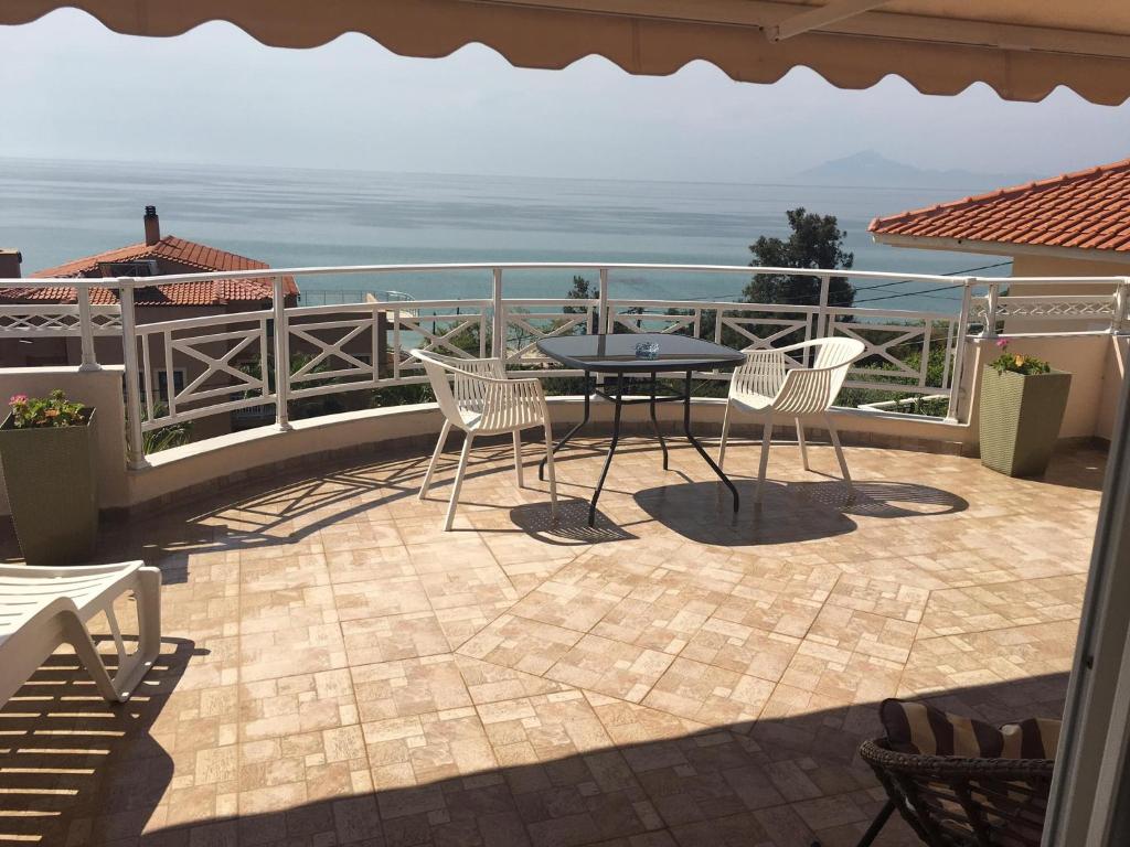 une terrasse avec une table et des chaises et l'océan dans l'établissement Gorgona Di Thassos, à Limenaria