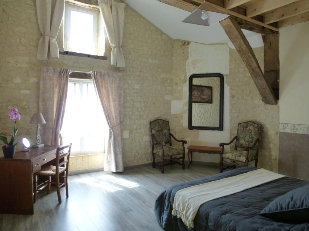 a bedroom with a bed and a desk and a window at LES COTEAUX DE VIGNY 