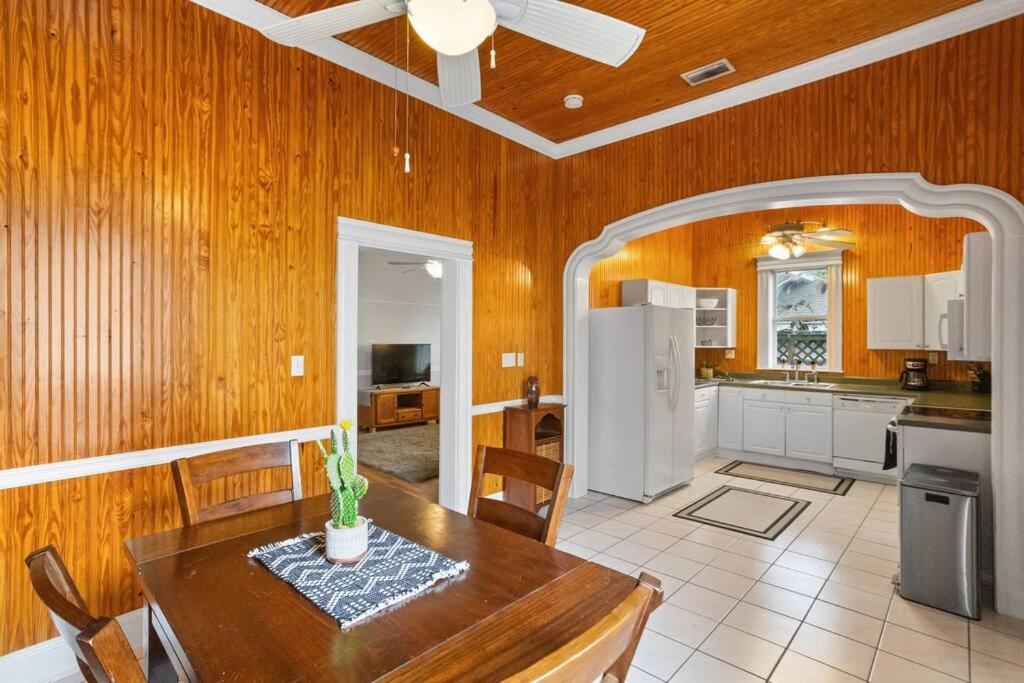 a kitchen and dining room with a table and a refrigerator at The Bays Best Bungalow in Tampa
