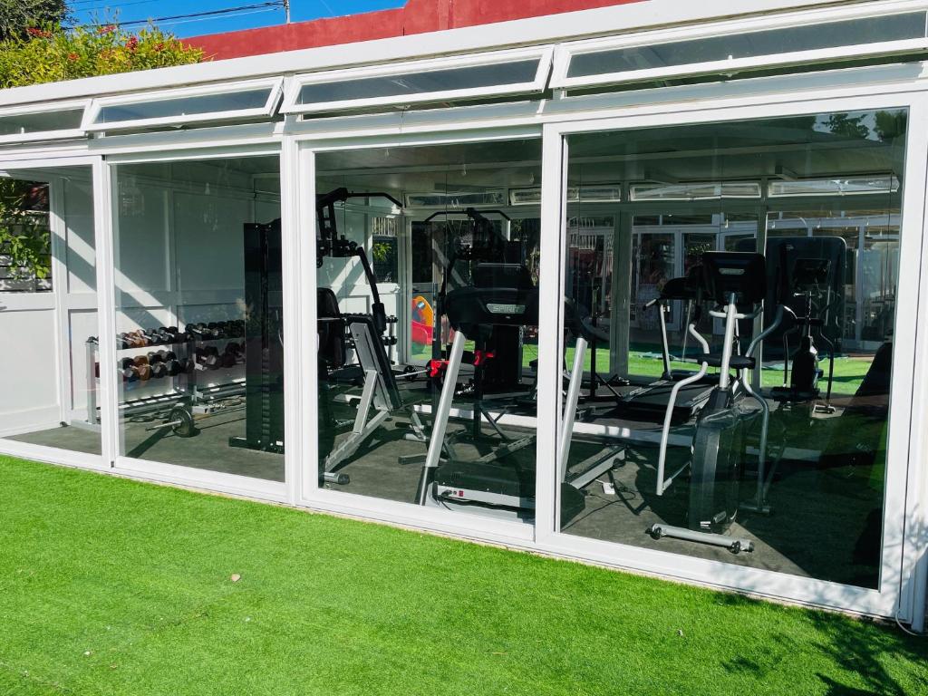 a gym with glass windows in a building at The Red Farm Relais & Spa in LʼInglin