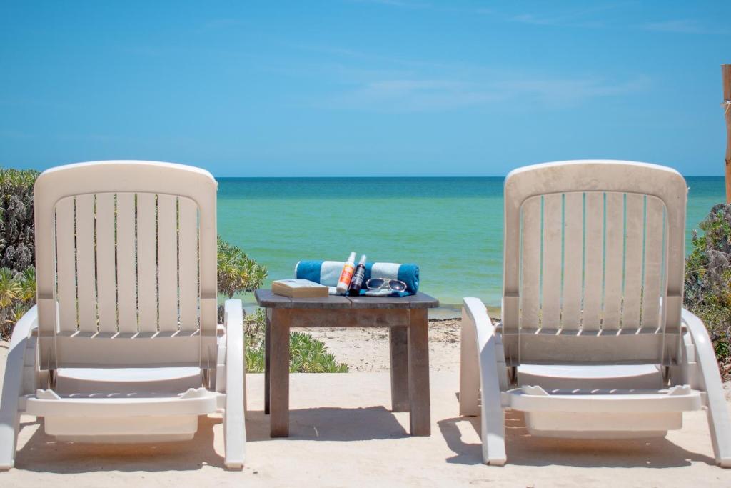 Tecnohotel Beach في San Benito: كرسيين وطاولة على الشاطئ