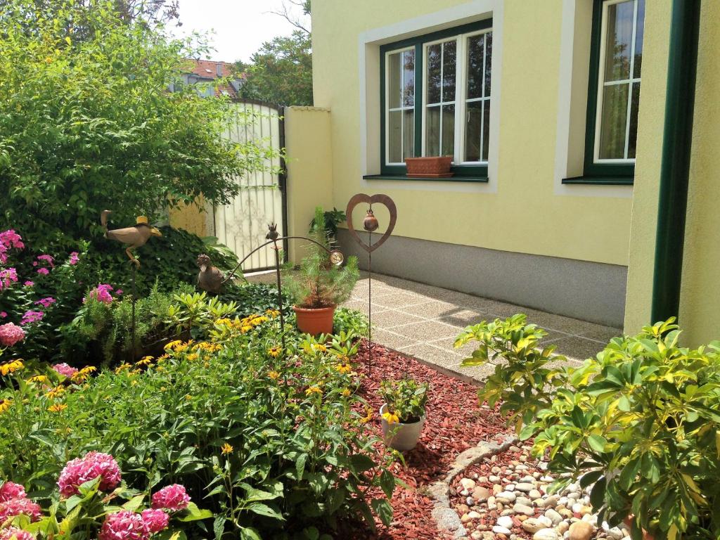 einen Garten mit Blumen und Pflanzen vor einem Haus in der Unterkunft Nikolaushof in Podersdorf am See