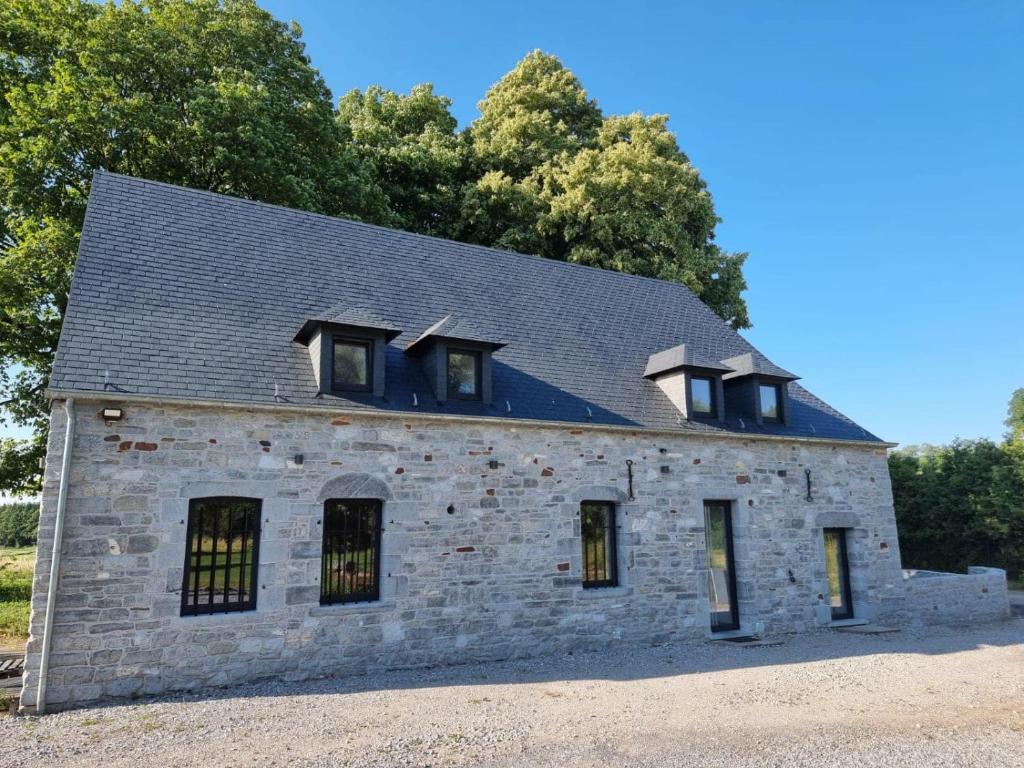 an old stone building with windows on top of it at Petit gîte du Moulin de Bourges in Momignies