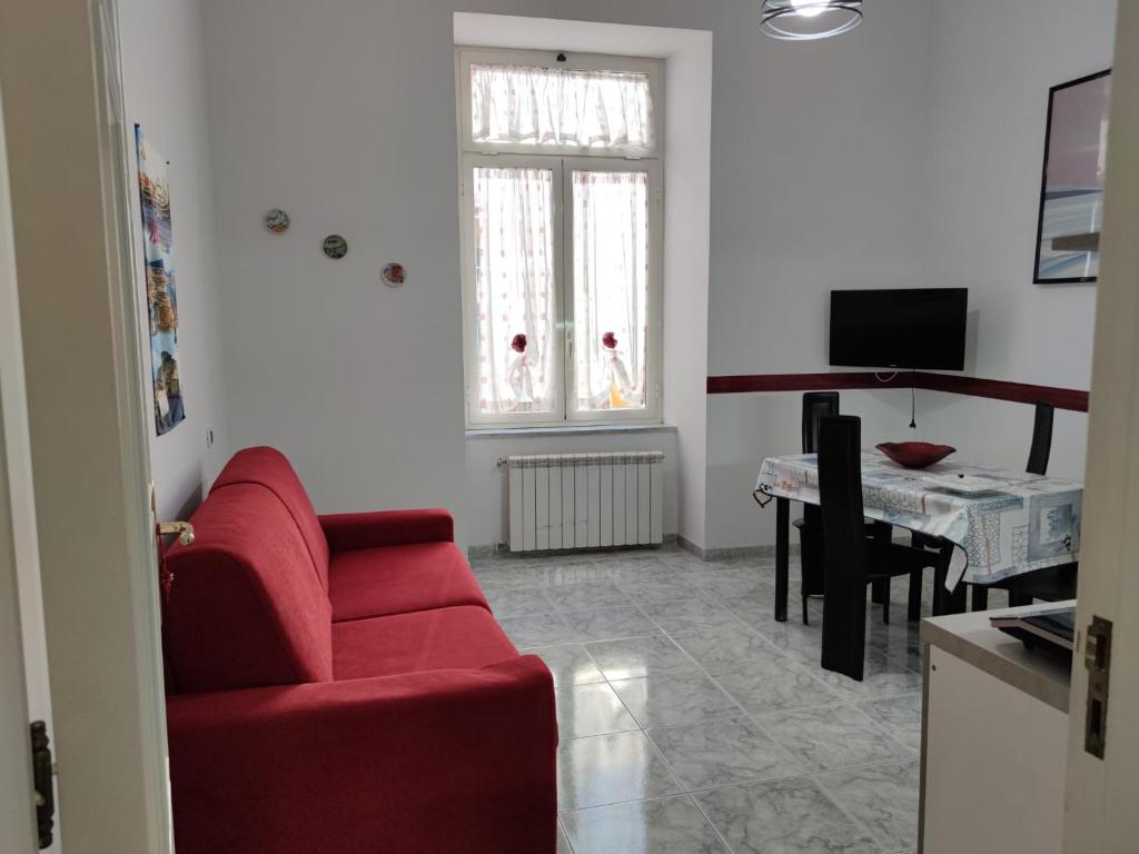 ein Wohnzimmer mit einem roten Sofa und einem Tisch in der Unterkunft GevyNapule in Neapel
