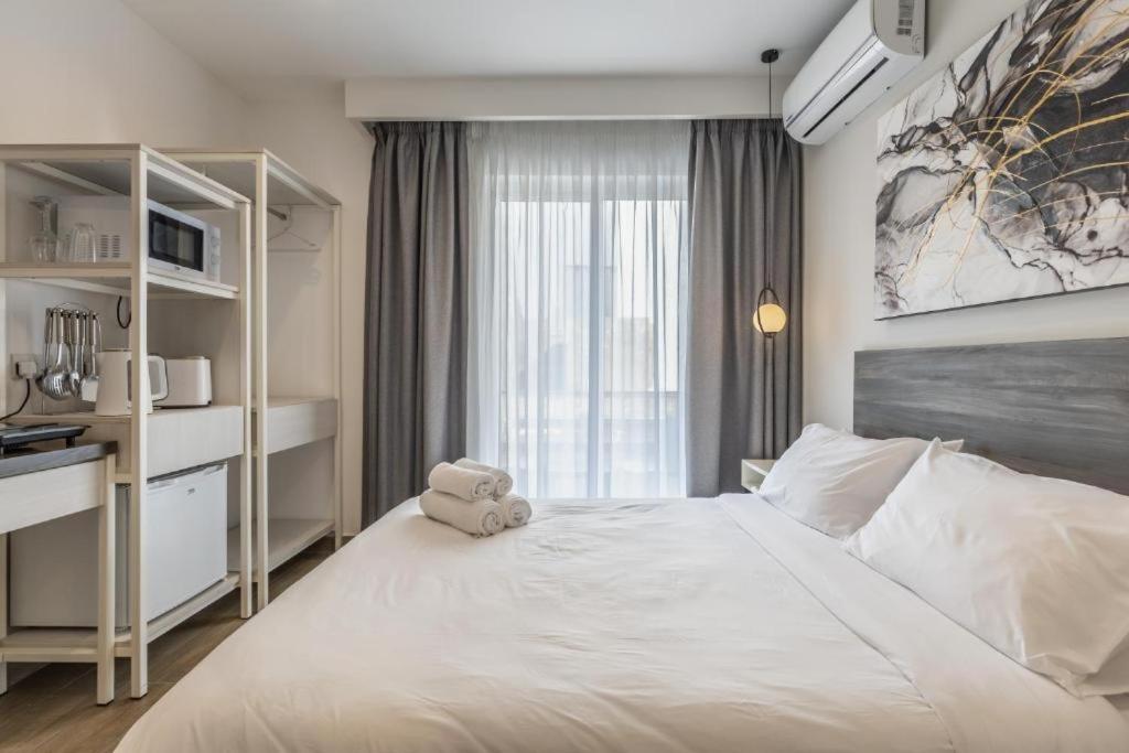 una camera da letto con un letto bianco e un orsacchiotto sopra di Studio 21 with kitchenette at the new Olo living a Paceville