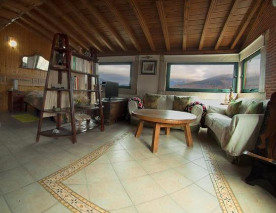 sala de estar con sofá y mesa en Apartamento Rural El Herrero vistas espectaculares a Gredos en Cabezas Bajas