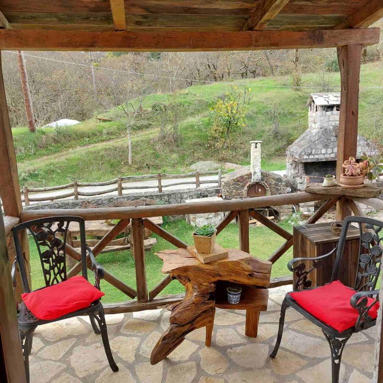 eine Veranda mit zwei Stühlen und einem Tisch und einem Grill in der Unterkunft Σαν Παραμυθάκι in Filýra