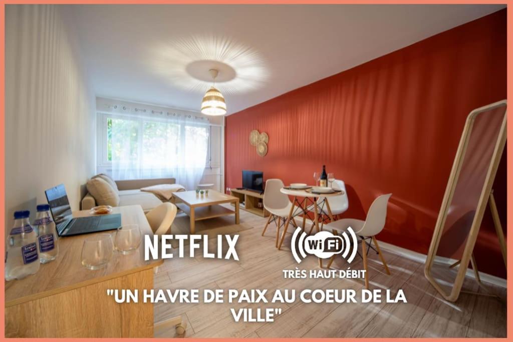 uma sala de estar com uma parede vermelha em L'escale mauricienne em Chalon-sur-Saône