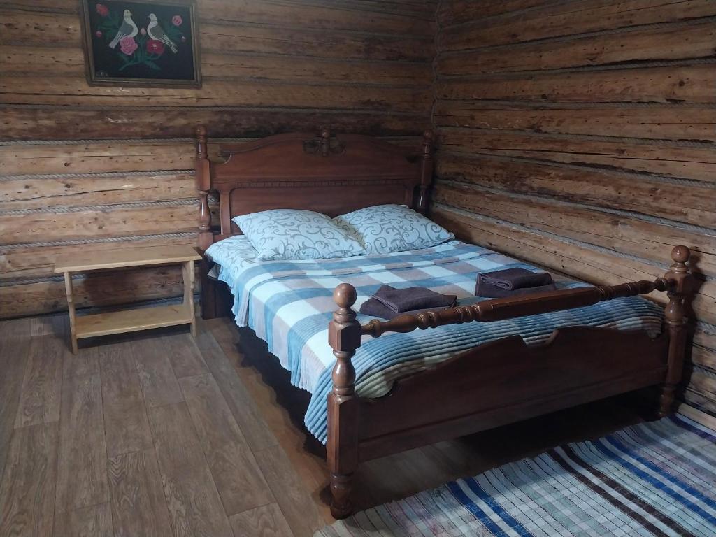 Затишна хата في Huklyvyy: غرفة نوم مع سرير في كابينة خشب