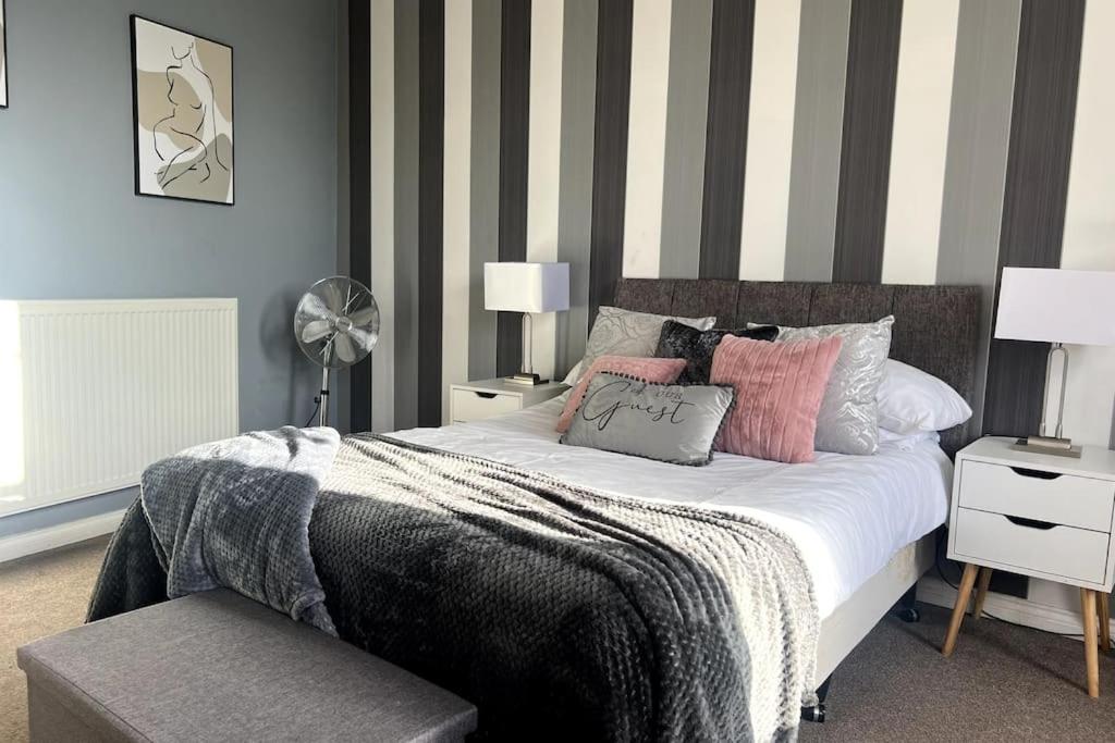 ein Schlafzimmer mit einem Bett mit gestreifter Wand in der Unterkunft Luxury Suite in Colchester Town Centre By Station in Colchester