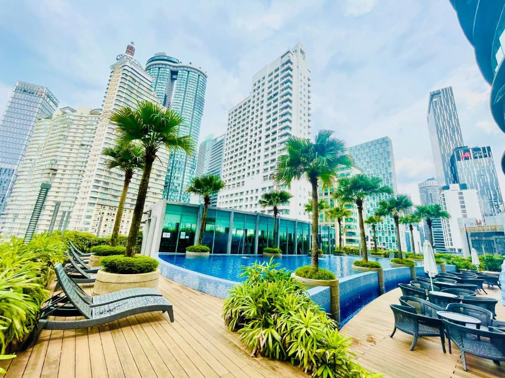 um resort com piscina, palmeiras e edifícios em Vortex suites klcc by Yashrib em Kuala Lumpur