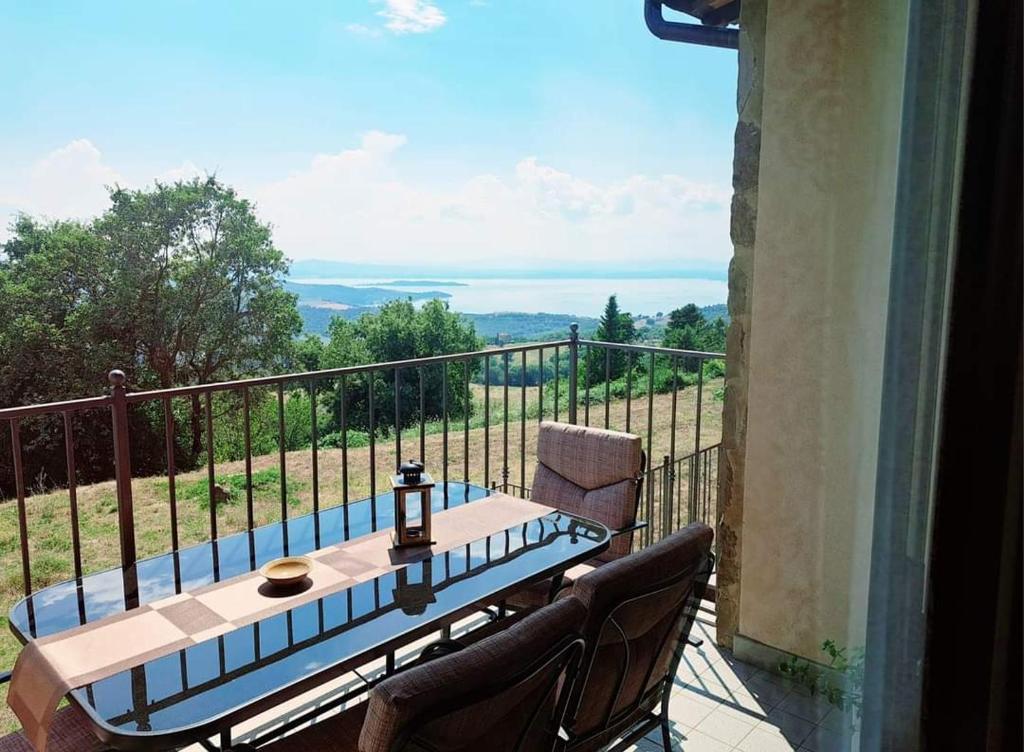 d'une table et de chaises sur un balcon avec vue. dans l'établissement Casa Vacanze La Perla del Lago, à Passignano sul Trasimeno