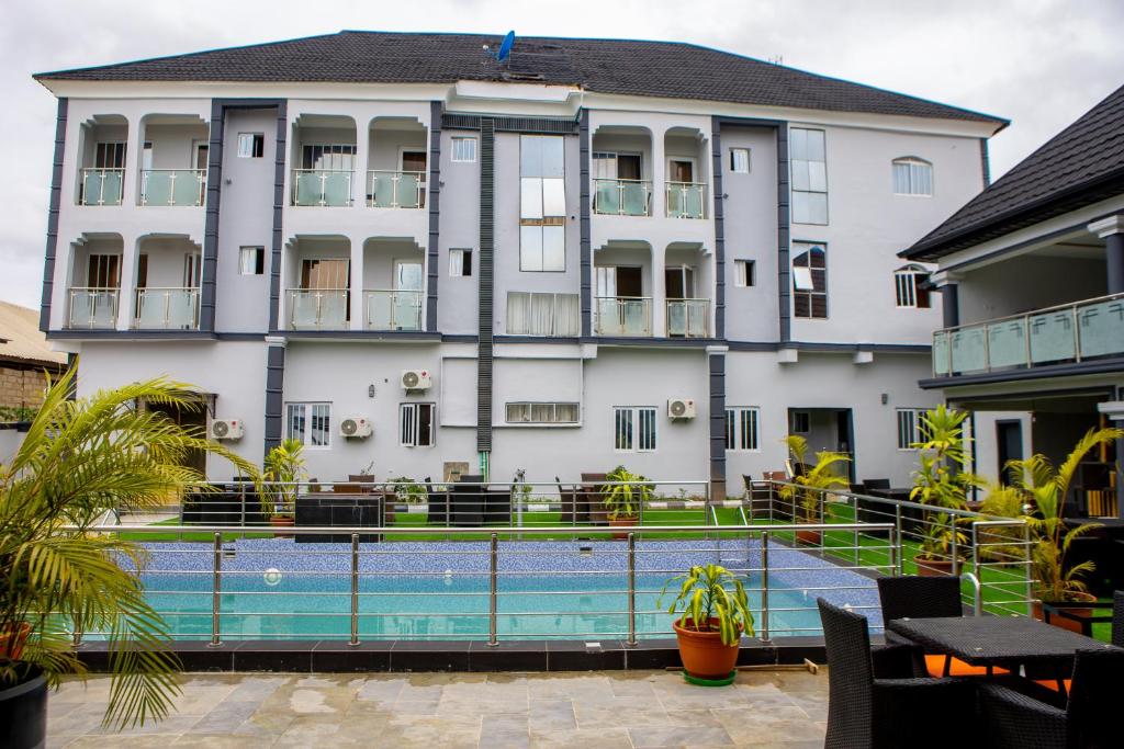 a hotel with a swimming pool in front of a building at Wingate Exotic in Ilorin