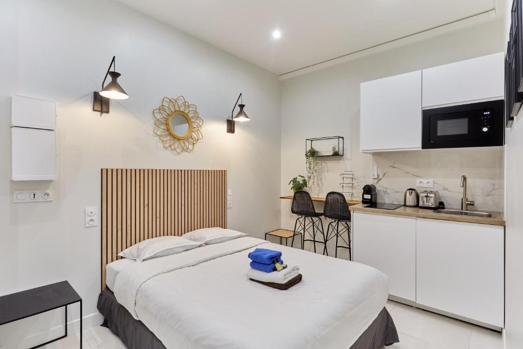 une chambre avec un grand lit et une cuisine dans l'établissement Rent a Room - Residence Charon, à Paris