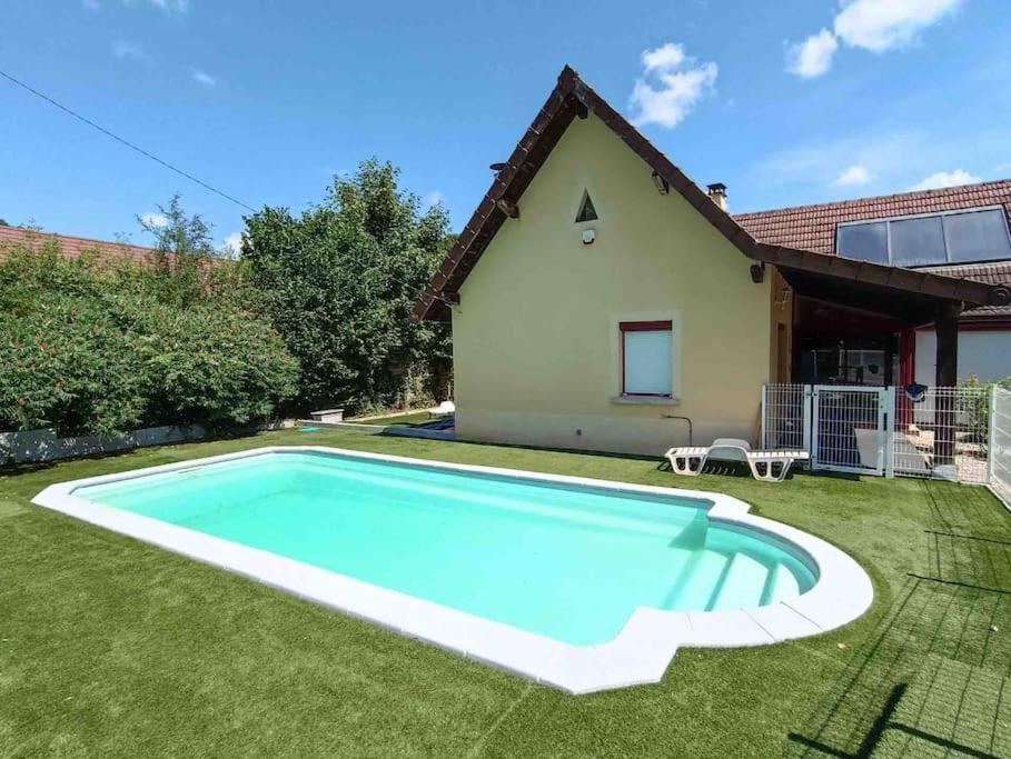 a swimming pool in the yard of a house at Maison de campagne avec piscine in Courbouzon