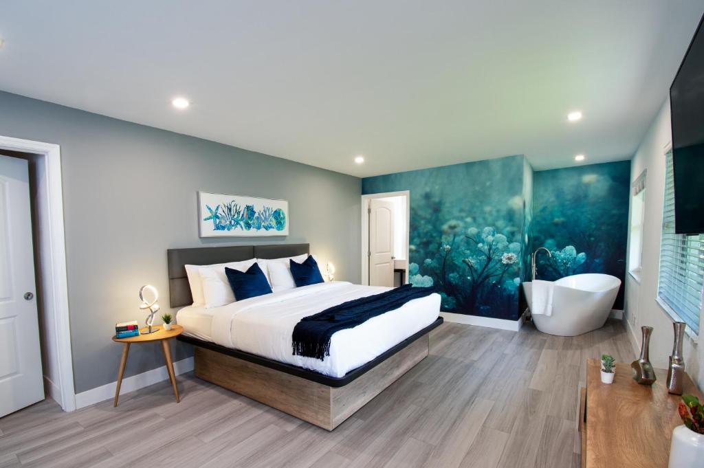 a bedroom with a large bed and a bath tub at The Lauderdale Boutique Hotel in Fort Lauderdale