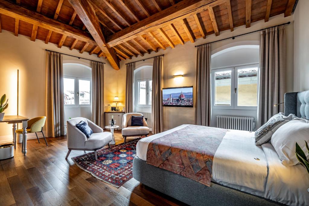 Dimora Collection - Le Torri - Boutique Luxury Suites - Adults Only في فلورنسا: غرفة نوم بسرير كبير وكراسي ونوافذ