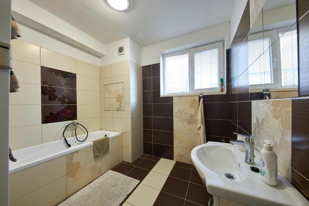 W łazience znajduje się umywalka, wanna i umywalka. w obiekcie Relaxi w Bratysławie