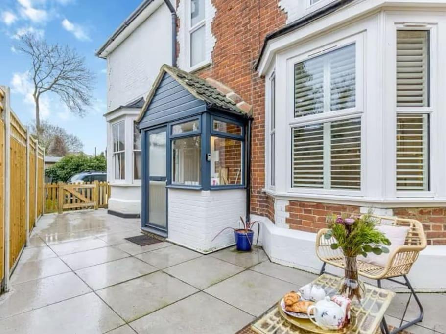 a blue and white house with a patio at The Railway Cottage - Stylish & Dreamy Home in the Heart of Whitstable in Kent