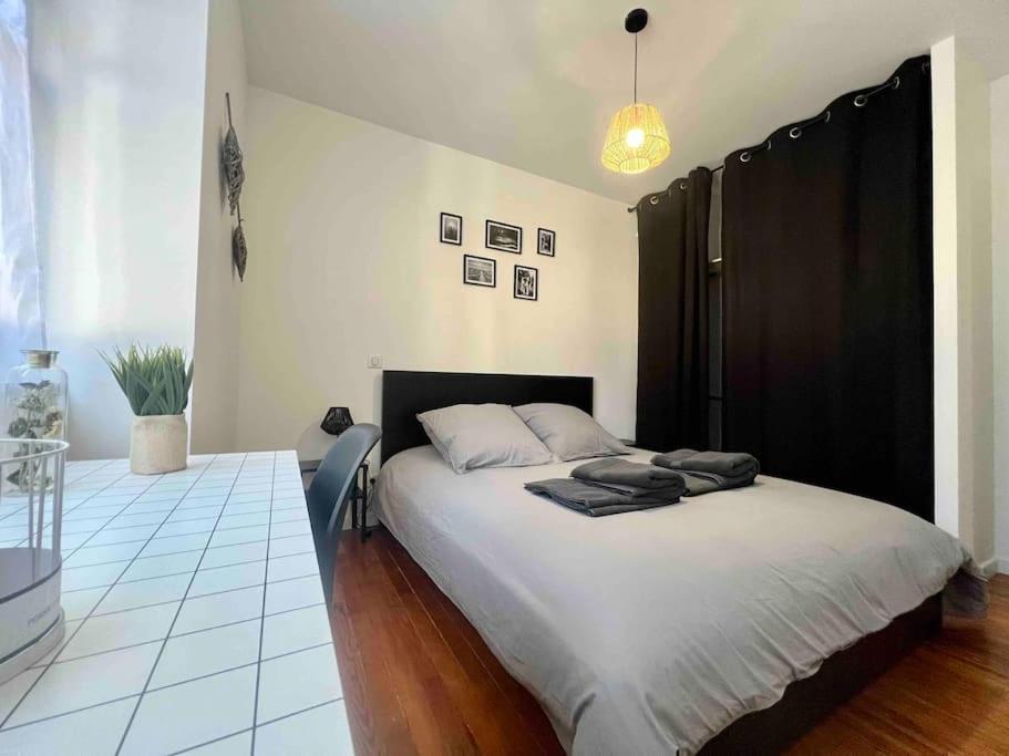 une chambre avec un grand lit avec une tête de lit noire dans l'établissement Appartement Climatisé 4 personnes / Centre-ville, à Besançon